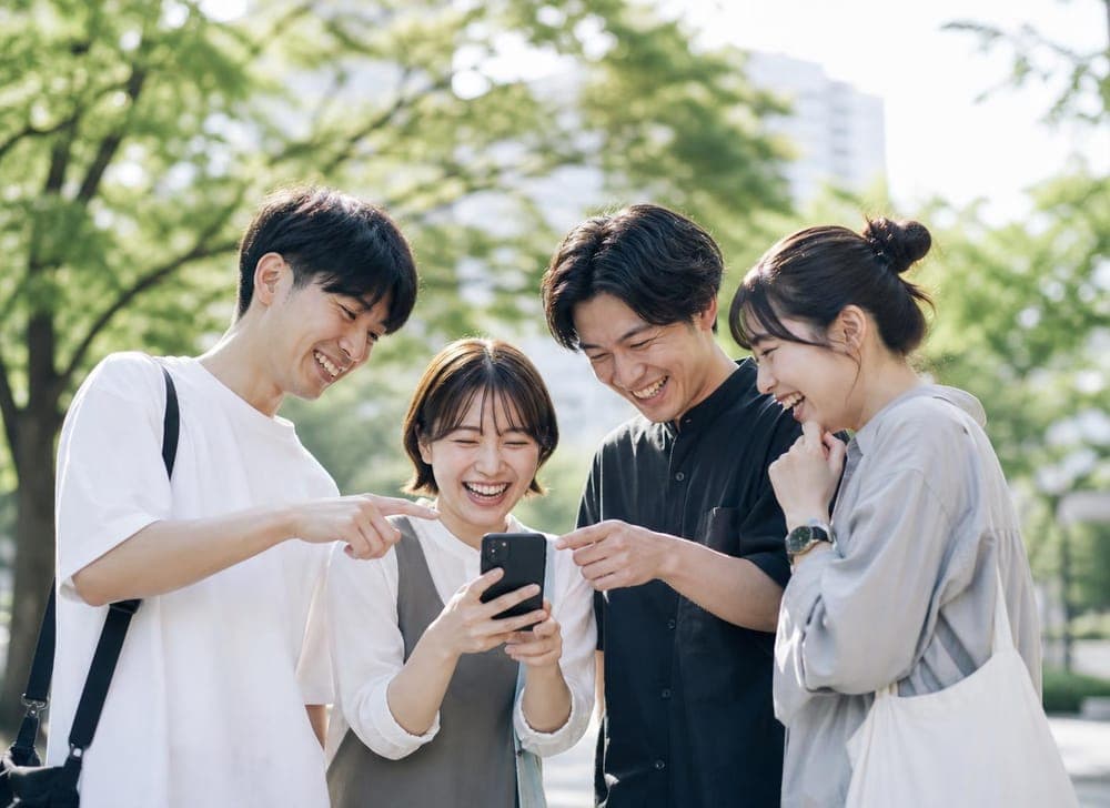 スマホを一緒にのぞき込む仲間たち